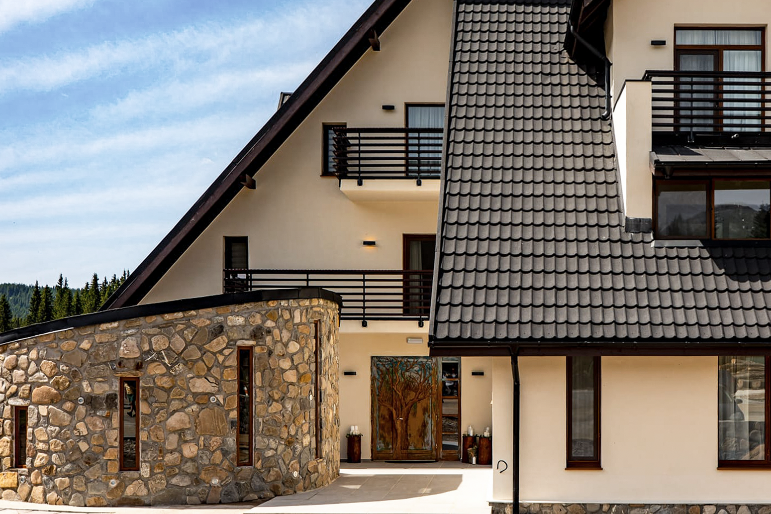 O pensiune moderna la munte cu placaj de piatra pe fatada.