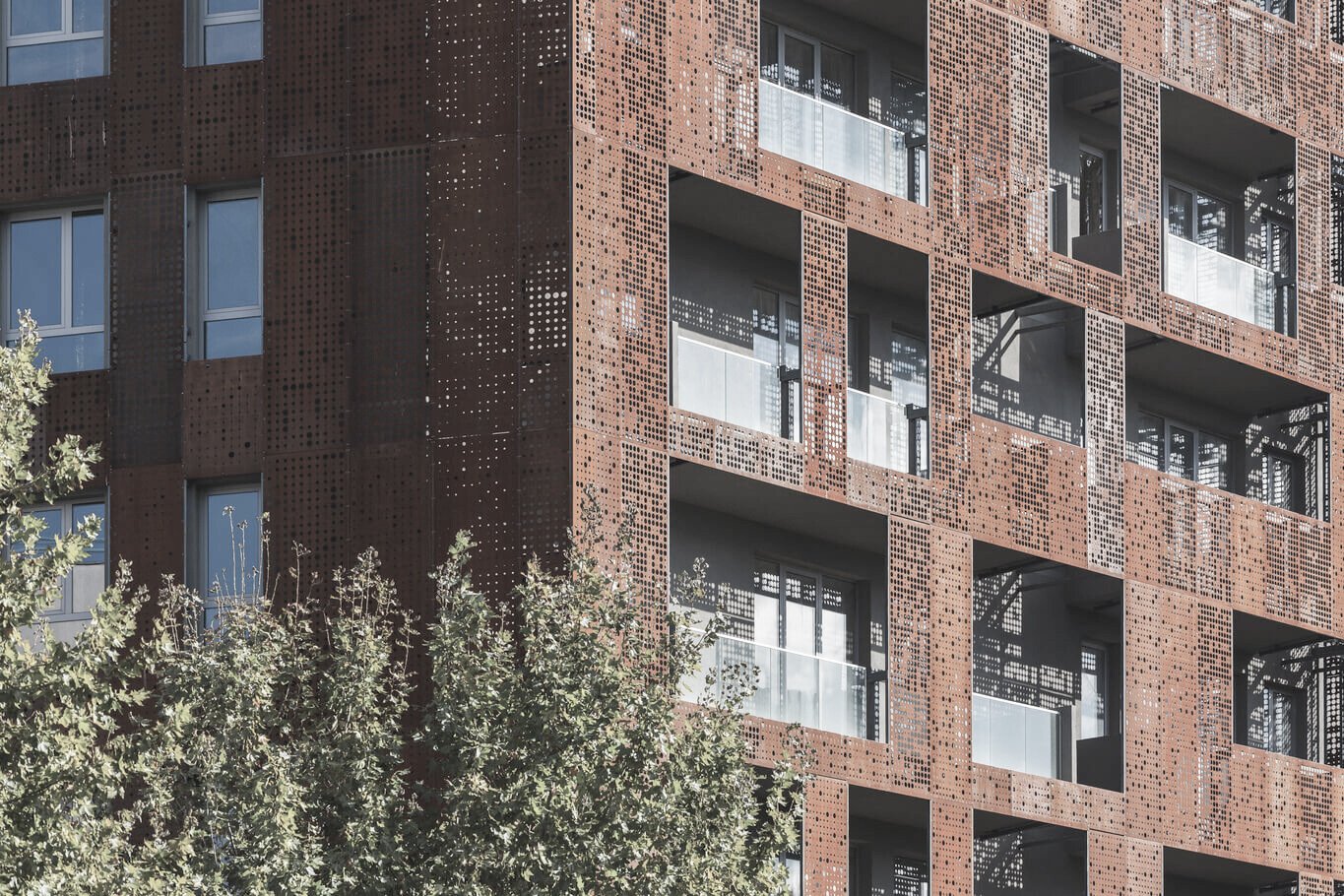 O cladire de birouri cu fatada de corten rosu perforat.